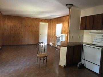 Eunice house for rent - A kitchen with a chair and a refrigerator.