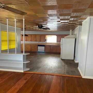 Eunice house for rent - an empty kitchen with wood floors and a refrigerator