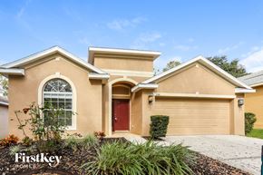 Valrico house for rent - A beige house with a red door and a garage door is for sale.