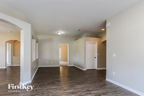 Valrico house for rent - A spacious room with wooden floors and white walls, with a door on the right side.