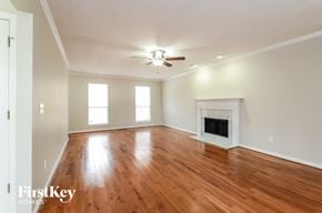 Alabaster house for rent - A spacious room with a fireplace and wooden floors.