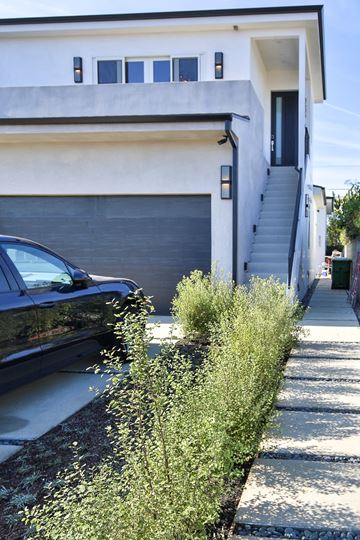Los Angeles apartment for rent - A black car is parked in front of a white house.