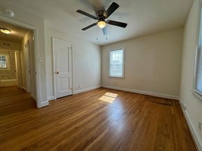 Winston Salem apartment for rent - A room with a ceiling fan and wooden flooring.
