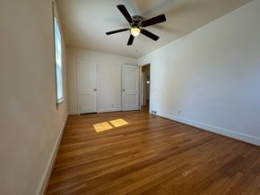 Winston Salem apartment for rent - A room with a ceiling fan and wooden floors.