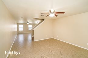 Converse house for rent - an empty living room with a ceiling fan and a white wall