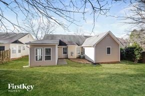 Charlotte house for rent - a small pink house with a yard and a grassy yard