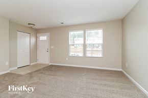 Clayton house for rent - A spacious room with a carpeted floor and two doors.