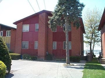 Port Washington apartment for rent - A red brick building with a tree in front.