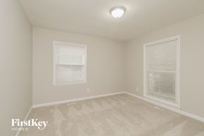 Gastonia house for rent - a bedroom with a carpeted floor and two windows