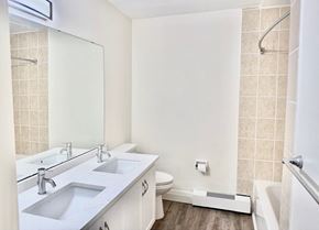 Guelph apartment for rent - A white bathroom with a toilet, sink, and bathtub.