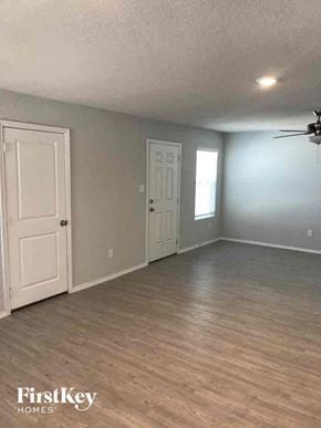 Converse house for rent - an empty living room with gray walls and a white door