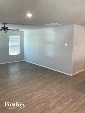 Converse house for rent - an empty living room with wood floors and a ceiling fan