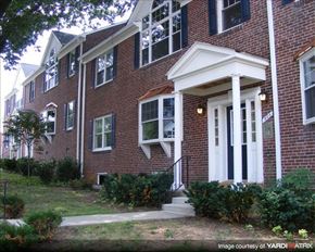 Baltimore apartment for rent - a brick house with a front porch and stairs