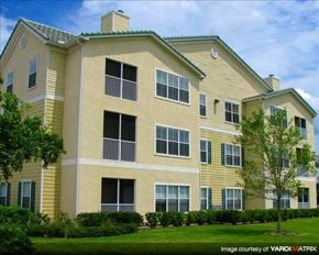 Wesley Chapel apartment for rent - a yellow apartment building with a green lawn