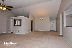 Saint Charles house for rent - A spacious room with a ceiling fan and a chandelier.