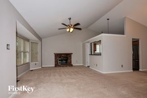 Saint Charles house for rent - A spacious living room with a fireplace and a ceiling fan.