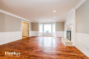 Lilburn house for rent - an empty living room with wood flooring and a fireplace