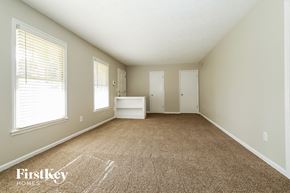 Lilburn house for rent - a spacious living room with carpeted floors and a large window