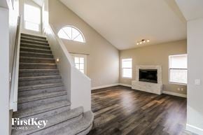 Gilbert house for rent - an open living room with a staircase and a fireplace