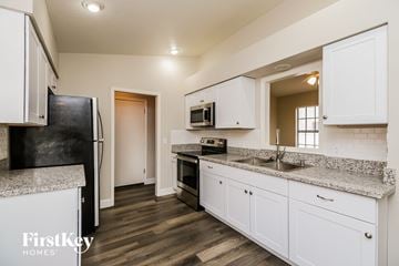 Gilbert house for rent - a kitchen with white cabinets and granite counter tops