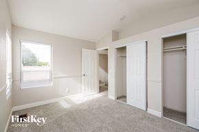 Gilbert house for rent - a bedroom with two closets and a window and a carpeted floor