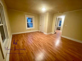 Slater-Marietta house for rent - A room with wooden floors and a window with a view of a building outside.