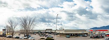 Colorado Springs apartment for rent - A parking lot with a large building in the background.