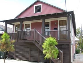 New Orleans apartment for rent - a red house with a porch and a staircase