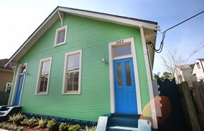 New Orleans apartment for rent - A green house with a blue door and a number 1822 on the front.