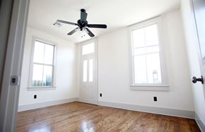 New Orleans apartment for rent - A room with a ceiling fan and three windows.