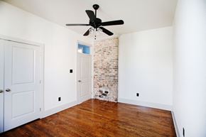 New Orleans apartment for rent - A room with a ceiling fan and a brick wall.