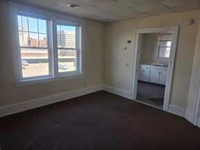 Canton apartment for rent - A room with a large window and a view of a parking lot and buildings outside.