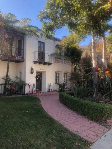 Long Beach apartment for rent - A white building with a balcony and a black door.