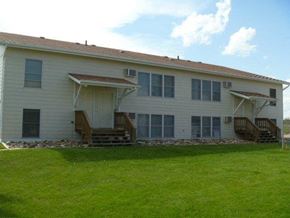 Williston apartment for rent - a white house with a green lawn in front of it