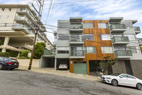 San Francisco apartment for rent - A modern apartment building with a white car parked in front.