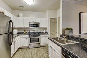 Aurora apartment for rent - the preserve at ballantyne commons apartment kitchen with stainless steel appliances and white cabinets