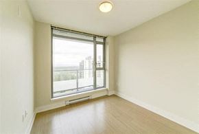 Coquitlam apartment for rent - an empty living room with a large window and wood floors