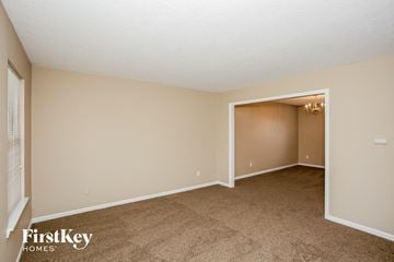 Fishers house for rent - a living room with carpet and an open door to a bedroom