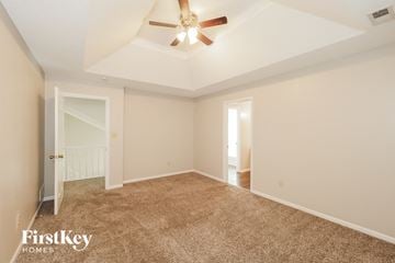 Belton house for rent - a spacious living room with carpet and a ceiling fan