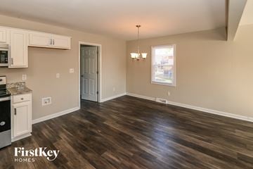 Monroe house for rent - A kitchen with a stove top oven and a dining room table.