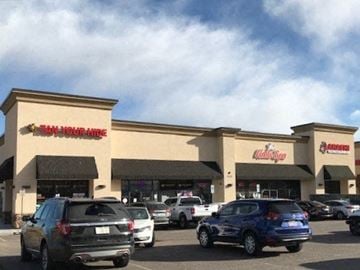 Fountain apartment for rent - a shopping mall with cars parked in a parking lot