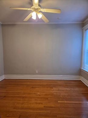 Chicago apartment for rent - A room with a ceiling fan and wooden floors.