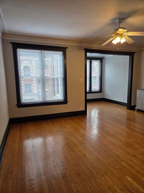 Chicago apartment for rent - A room with wooden floors and a ceiling fan.