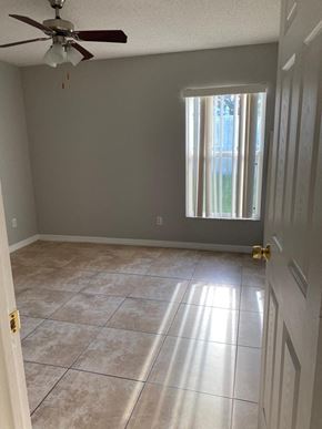 Orlando house for rent - a empty room with a ceiling fan and a window