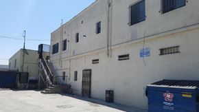 Compton apartment for rent - the side of a white building with a staircase and a blue container