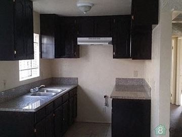 Los Angeles apartment for rent - an empty kitchen with black cabinets and a sink