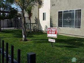 Los Angeles apartment for rent - a red and white sign in the grass in front of a building