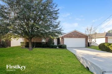 Conroe house for rent - a house with a driveway and a garage door