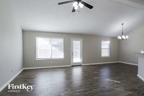 Conroe house for rent - an empty living room with wood floors and a ceiling fan