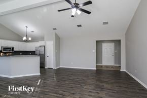 Conroe house for rent - an empty kitchen and living room with a ceiling fan